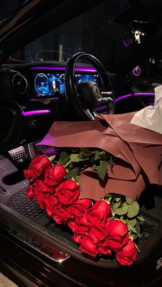 a bunch of roses that are sitting in the back of a car with paper on it