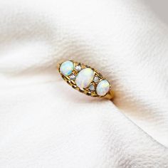 Here we have a lovely antique classic opal and diamond ring. The ring features three cabochon opals with incredible play of colour which have been set in an 18ct yellow gold setting with rose cut diamonds in between each stone.  Total Diamond Weight: 0.10cts (Approx) Age: Edwardian   Metal: 18ct Yellow Gold Marked: '18ct' Ring Size: M Weight: 2.0 grams Condition: Very Good (Rings over £300 can be resized free of charge. All rings under £300, please enquire about cost to resize) (Layaway availabl Good Rings, Opal And Diamond Ring, Diamond Three Stone Ring, Three Stone Ring, Yellow Gold Setting, Rings Cool, Three Stone Rings, Rose Cut Diamond, Three Stone