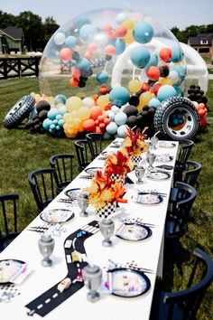 a long table is set with balloons and plates