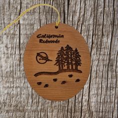 a wooden ornament with the words california redwoods and pine trees on it