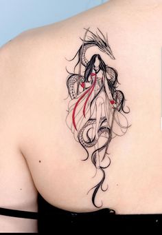 the back of a woman's shoulder with an artistic tattoo design on her left shoulder