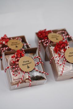 three small boxes with red and white twine tied around the top one has a tag that says merry christmas on it