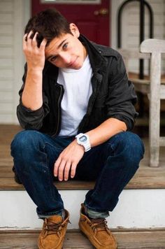 a young man sitting on the steps with his hands to his face