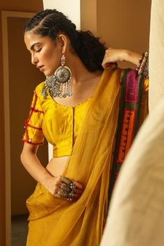 Yellow blouse with deep back, placement mirror work and hand embroidered sleeves.
Component: 1
Embroidered
Neckline: Round
Sleeve Length: Half
Fabric: Handwoven Chiniya Silk
Color: Yellow
Backless blouse
Closure: Concealed front placket
Note: Saree worn by the model is not for sale - Aza Fashions Mirror Work Saree Blouse, Yellow Mirror, Mirror Work Saree, Saree Blouses Online, Yellow Saree, Backless Blouse, Silk Saree Blouse, Yellow Silk, Yellow Blouse