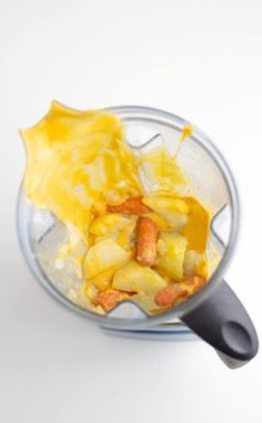 a blender filled with food on top of a white table