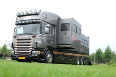 a large truck parked on top of a lush green field