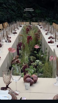 a long table is set up with flowers and vegetables