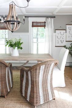 a dining room table with two chairs and a chandelier hanging from the ceiling