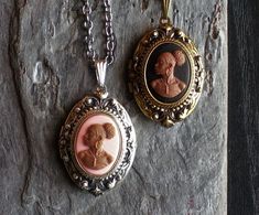 Detailed cameo set in detailed antique silver or antique brass on an antique silver or antique brass locket. Chain on the silver locket is gunmetal. Chain on the antique brass locket is also antique brass. Choose from a pink cameo or black cameo. Locket opens with two spaces for pictures. Details: Locket measures 1.25 inch x 7/8 inch Locket and chain are plated brass Gunmetal is shiny, dark grey plating Chain measures 18 inches Lead and nickel free Cameo is hard, matte resin You can find a numbe Bronze Oval Pendant Jewelry With Antique Finish, Bronze Oval Pendant With Antique Finish, Bronze Antique Finish Oval Pendant Jewelry, Antique Oval Pendant Jewelry With Antique Finish, Victorian Cameo Round Pendant Jewelry, Silver Cameo Round Pendant Jewelry, Antique Silver Necklace With Antique Finish For Collectors, Victorian Jewelry With Antique Finish Oval Pendant, Silver Cameo Jewelry With Round Pendant