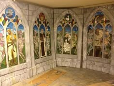 an empty room with stained glass windows in the wall and flooring on the ground