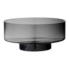 a glass bowl with black marble base on a white background