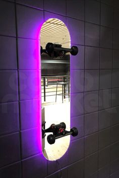 a bathroom mirror that has some lights on the side of it in front of a tiled wall