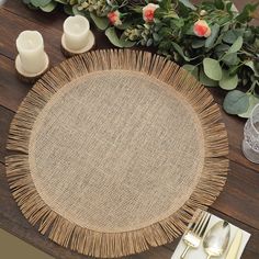 a place setting on a wooden table with flowers and candles