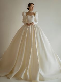 a woman in a wedding dress with long sleeves