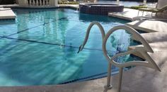 an empty swimming pool with chairs around it