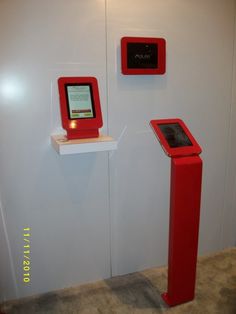 two red electronic devices are on display in a room with white walls and flooring