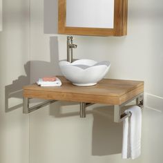 a bathroom sink with a wooden shelf underneath it and a mirror on the wall above it