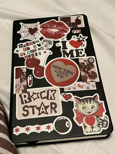 a laptop with stickers on it sitting on a bed