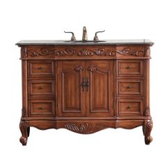 an antique style bathroom vanity with two sinks and carved wood accents on the cabinet doors