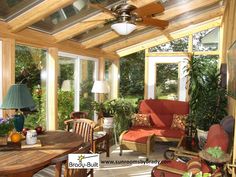 a sun room with couches, chairs and tables in it's center area