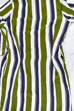 a green and white striped shirt laying on the ground