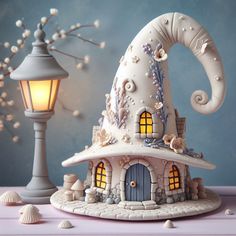 a small white house with an elephant on it's roof next to a lamp