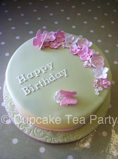 a birthday cake decorated with pink flowers and butterflies