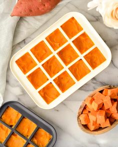 sweet potatoes and carrots on a marble counter top next to an ice cube tray