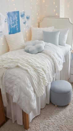 a white bed with pillows and blankets on it in a room decorated for christmas or new year's eve