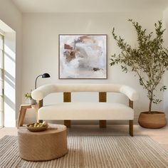 a living room with a white couch and potted plants