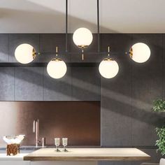 the lights are on above the counter in this modern style kitchen, and there is also a potted plant