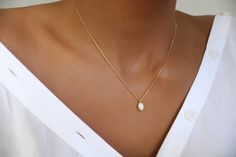 This dainty necklace features a small oval genuine Freshwater sits on a dainty and fine finish 18k gold-filled chain. You can wear this dainty necklace with your everyday jeans as well as on a night out. It will always look beautiful on you.     D E T A I L S  * Pearl measures approx 4mm * Due to the one-of-a-kind nature of the stones they may vary slightly in size color, hue, and reflection. Please note: This listing is for one necklace only. The model is layering it with one of our beautiful a Delicate Oval Necklace With Delicate Chain, Elegant Tiny Necklaces For Everyday, Elegant Tiny White Necklace, Delicate Oval Pearl Pendant Necklace, Dainty Oval Necklace With Delicate Chain, Minimalist Oval Necklaces For Wedding, Minimalist Oval Necklace For Wedding, Everyday Minimalist Teardrop Pearl Necklace, Delicate Everyday Oval Pendant Necklace