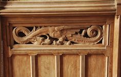 an ornate carved wooden panel on the side of a door with carvings and scrolls around it