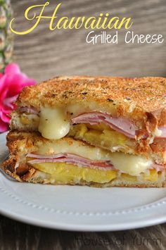 a grilled cheese sandwich with ham and pineapples on the side, sitting on a white plate