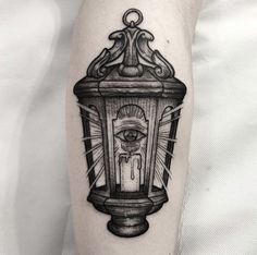 a black and white image of a lantern with an all seeing eye tattoo on it