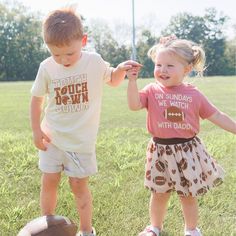 The Touchdown Echo Short Sleeve T-Shirt is a fun and handsome t-shirt for kids celebrating Game Day! Features: Shirt Color: Natural Graphic Color: Brown Material: 100% Cotton Features: Tagless inside neck label for an itch-free wear Fit: Toddler Unisex; True to Size Care: Machine washable, tumble dry low, wash with like colors Each t-shirt is hand pressed with love in our hometown warehouse. Cotton Short Sleeve T-shirt For Playdate, Cute Short Sleeve T-shirt For Game Day, Fun Cotton T-shirt For Playdate, Family Matching Short Sleeve Tops For Playwear, Soft-washed Crew Neck T-shirt For Playtime, Casual T-shirt For Playdate, Funny Short Sleeve Tops For Playtime, Casual Short Sleeve T-shirt For Playdate, Casual Tops With Graphic Print For Playdate