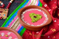 a bowl filled with food sitting on top of a colorful cloth covered table next to other items