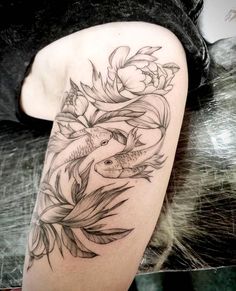 a woman's arm with flowers and fish tattoo on the left side of her body