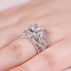 a close up of a person's hand with a diamond ring on their finger