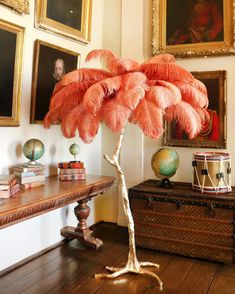 a room with pictures and paintings on the wall, including a tree in an antique trunk