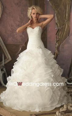 a woman in a wedding dress posing for the camera