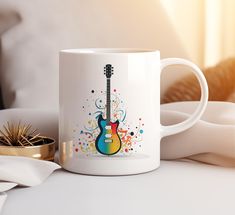 a white coffee mug with a colorful guitar on it