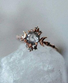 a close up view of a ring on top of a rock with the moon and stars in it