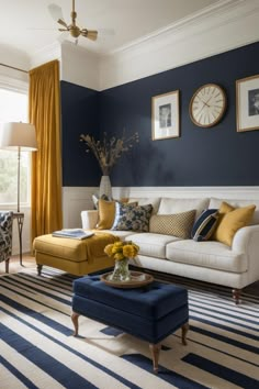 a living room with blue walls and yellow curtains on the window sill, white couches, and striped rugs