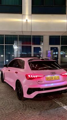 a pink car parked in front of a building