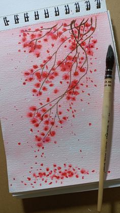 a brush is sitting on top of a paper with red paint splattered on it