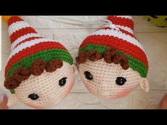 two crocheted elf slippers hanging from a wall