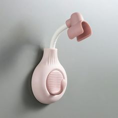 a pink hair dryer attached to a wall with a cord in the shape of a heart