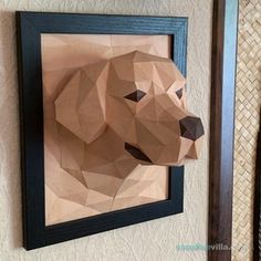 a paper sculpture of a bear is hanging on the wall