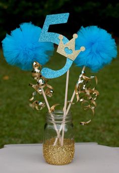 a blue and gold number five cake topper in a mason jar